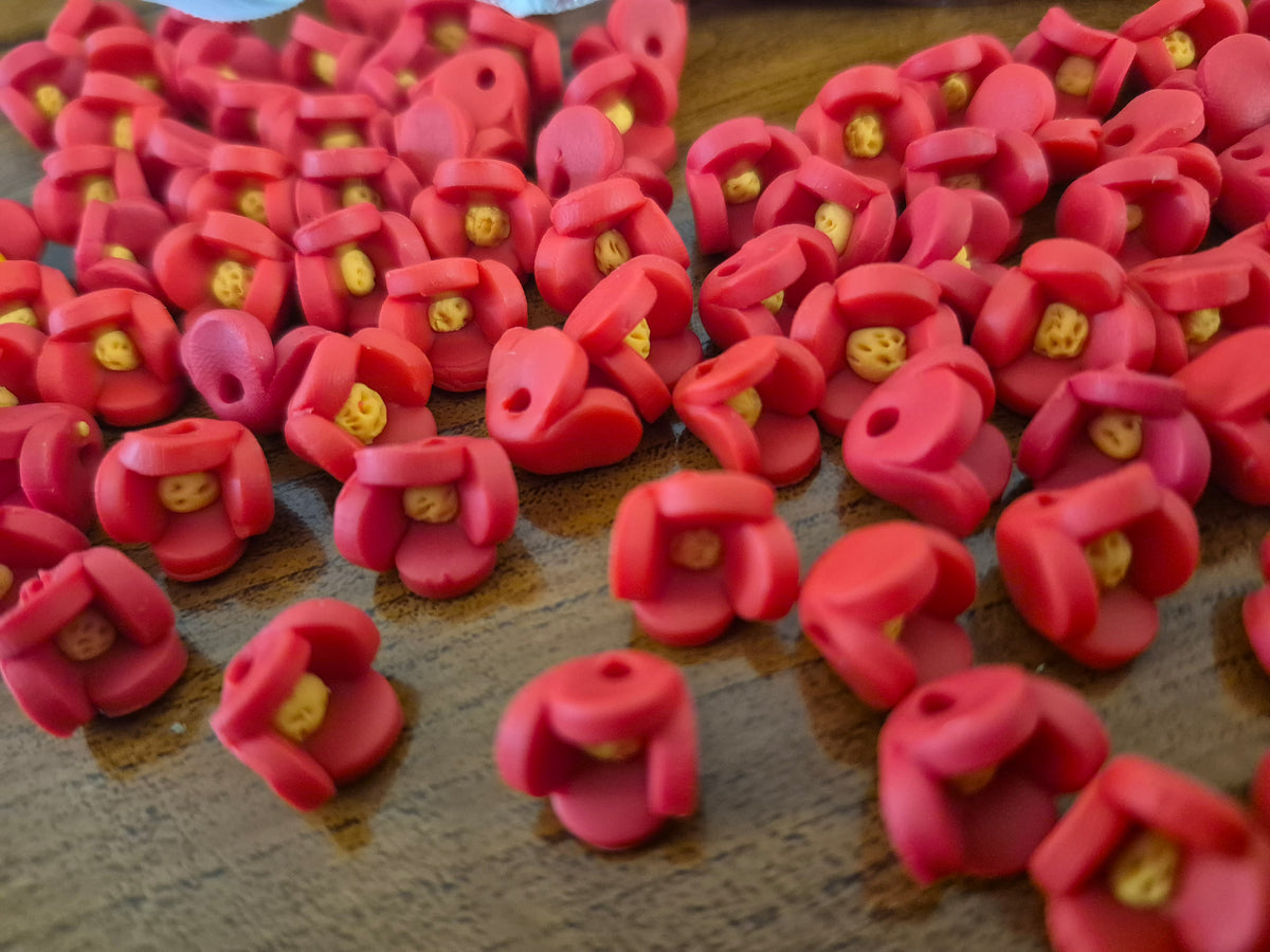 Close-up of pink flower-shaped beads with small yellow centers