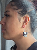 Long drop earrings with dark coconut halves and white insets on silver hooks