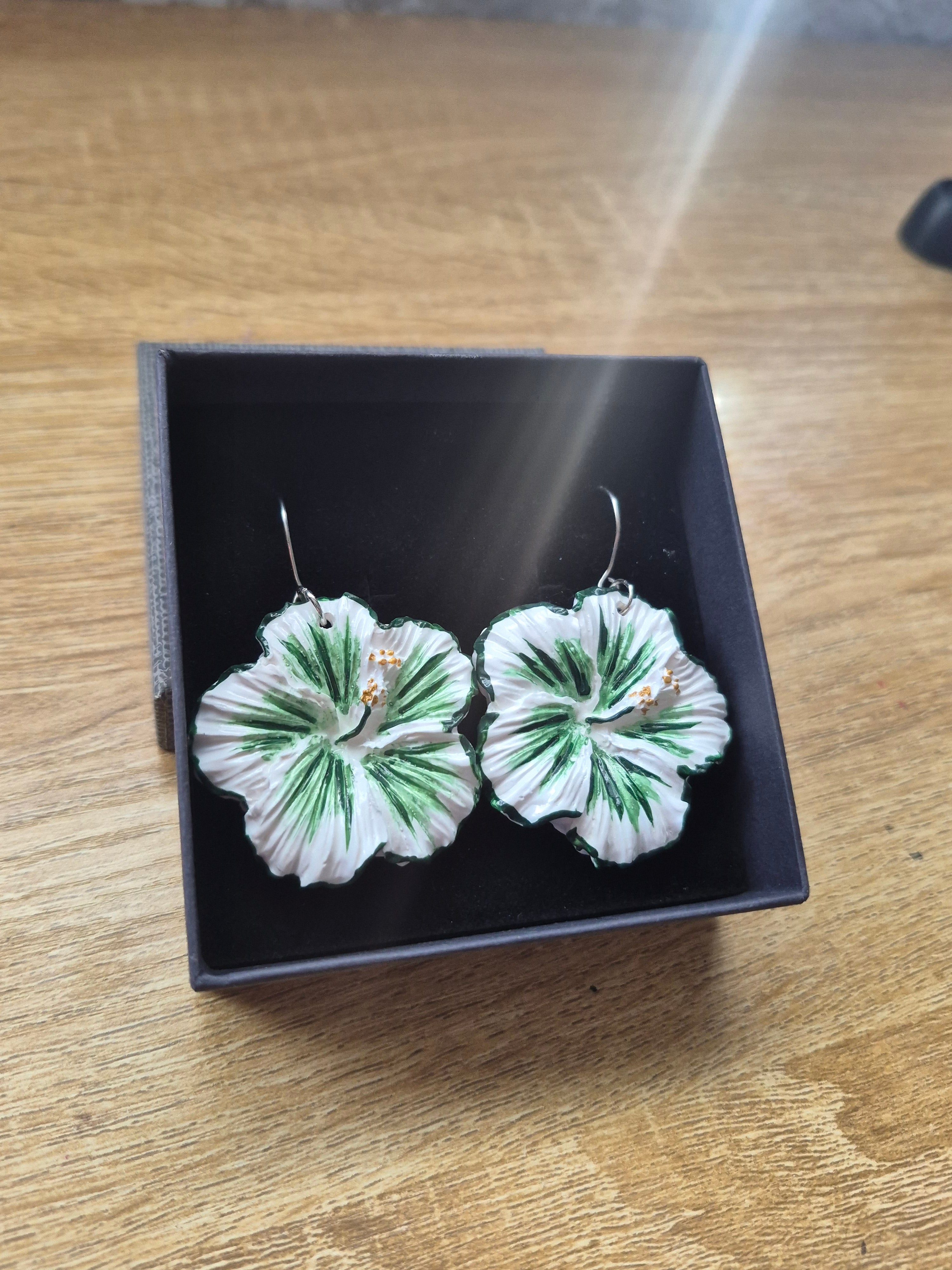 Pair of floral drop earrings in black box, green and white flower petals
