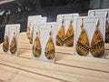Lo'imata gold and black geometric dangle earrings on display cards