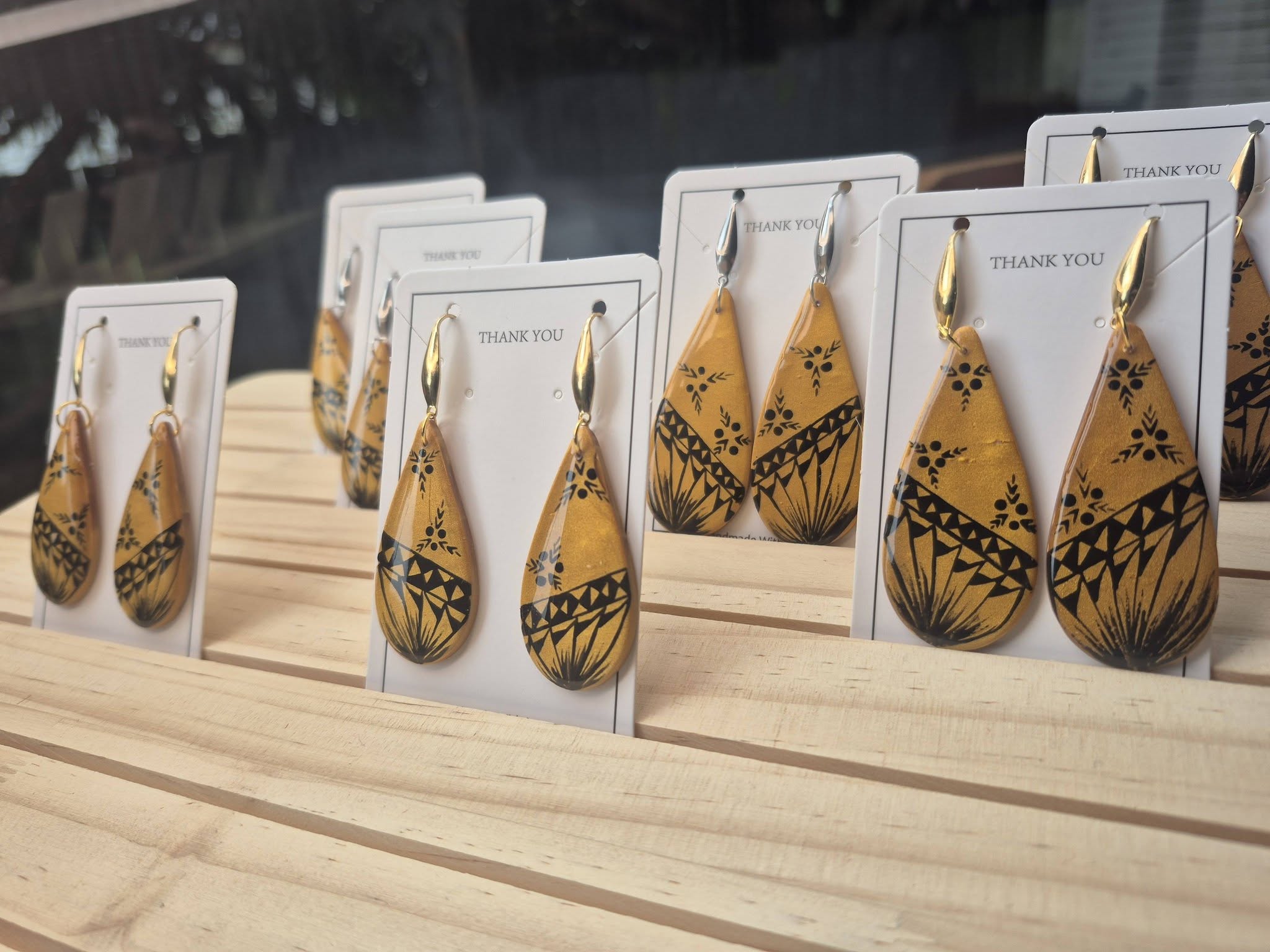 Lo'imata gold and black geometric dangle earrings on display cards