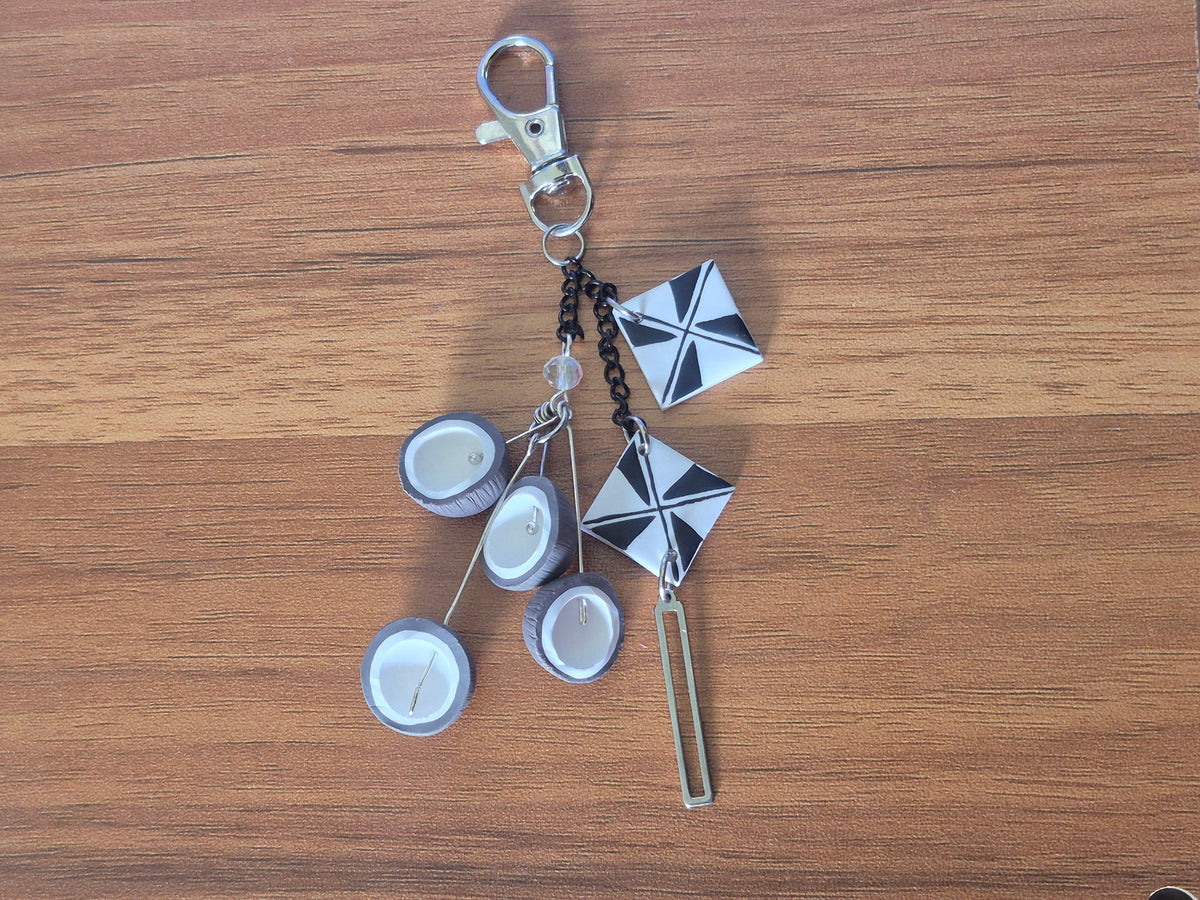 Silver keychain with three white discs, star charms, and key