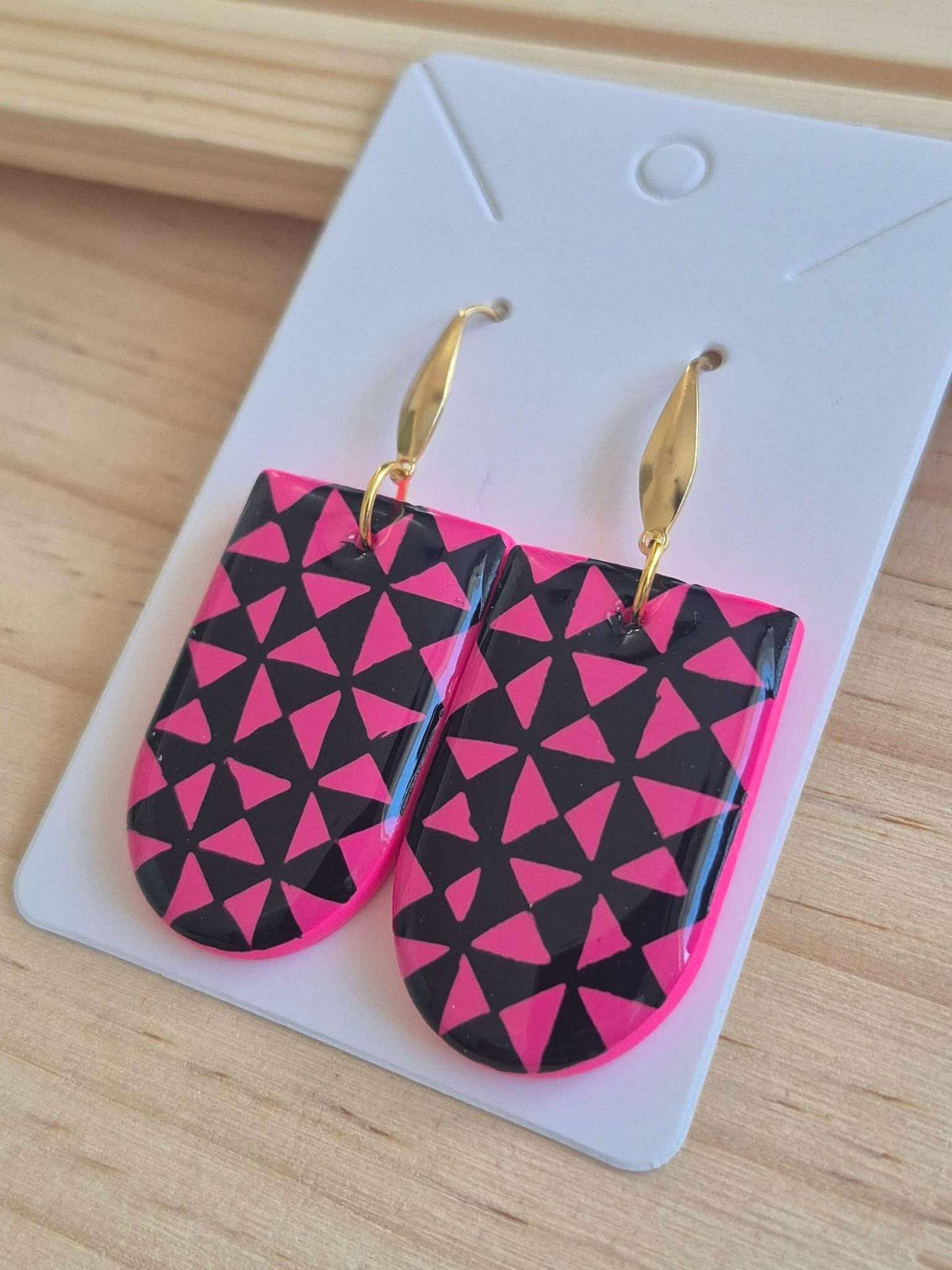 Geometric pink-and-black drop earrings with gold-tone dangling hooks