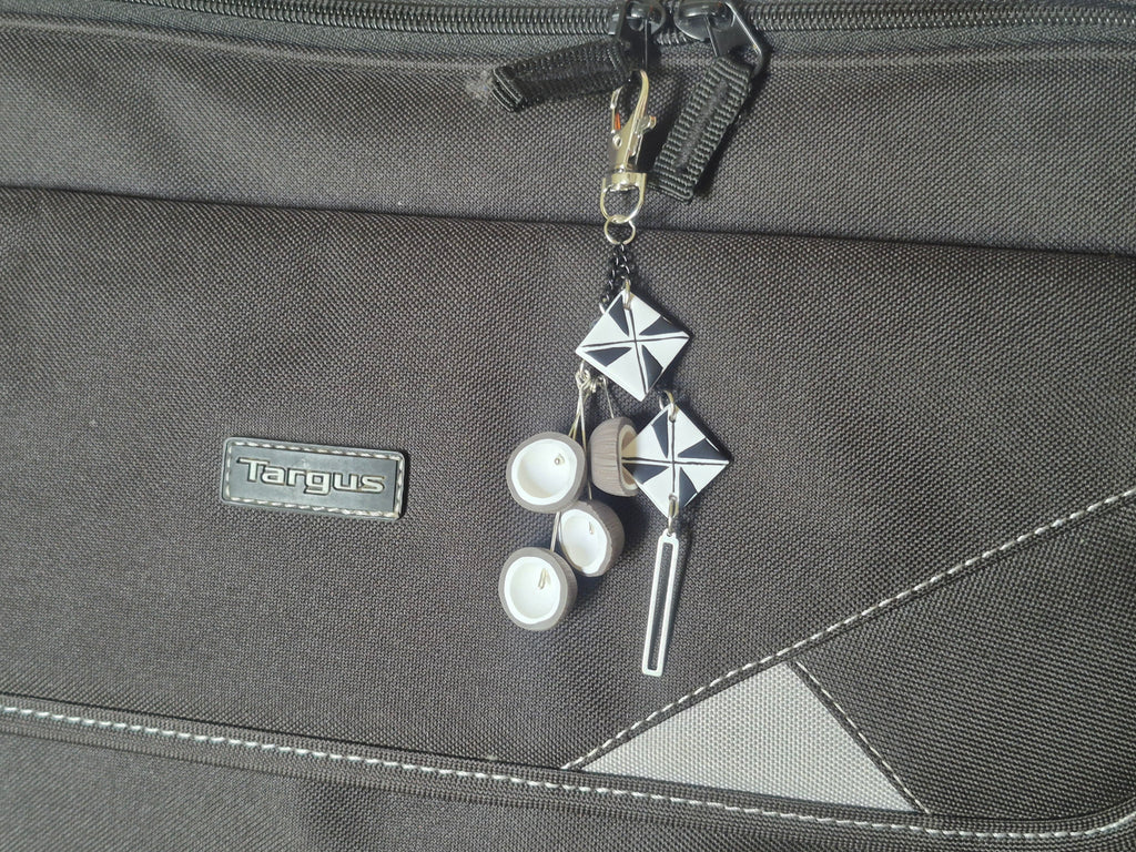 Silver geometric keychain with white discs and metal key charm