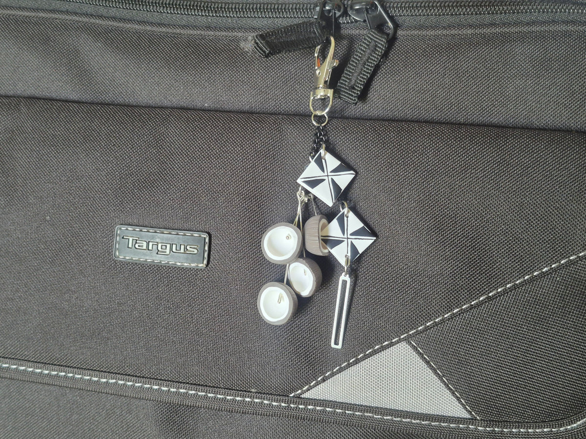 Silver geometric keychain with white discs and metal key charm