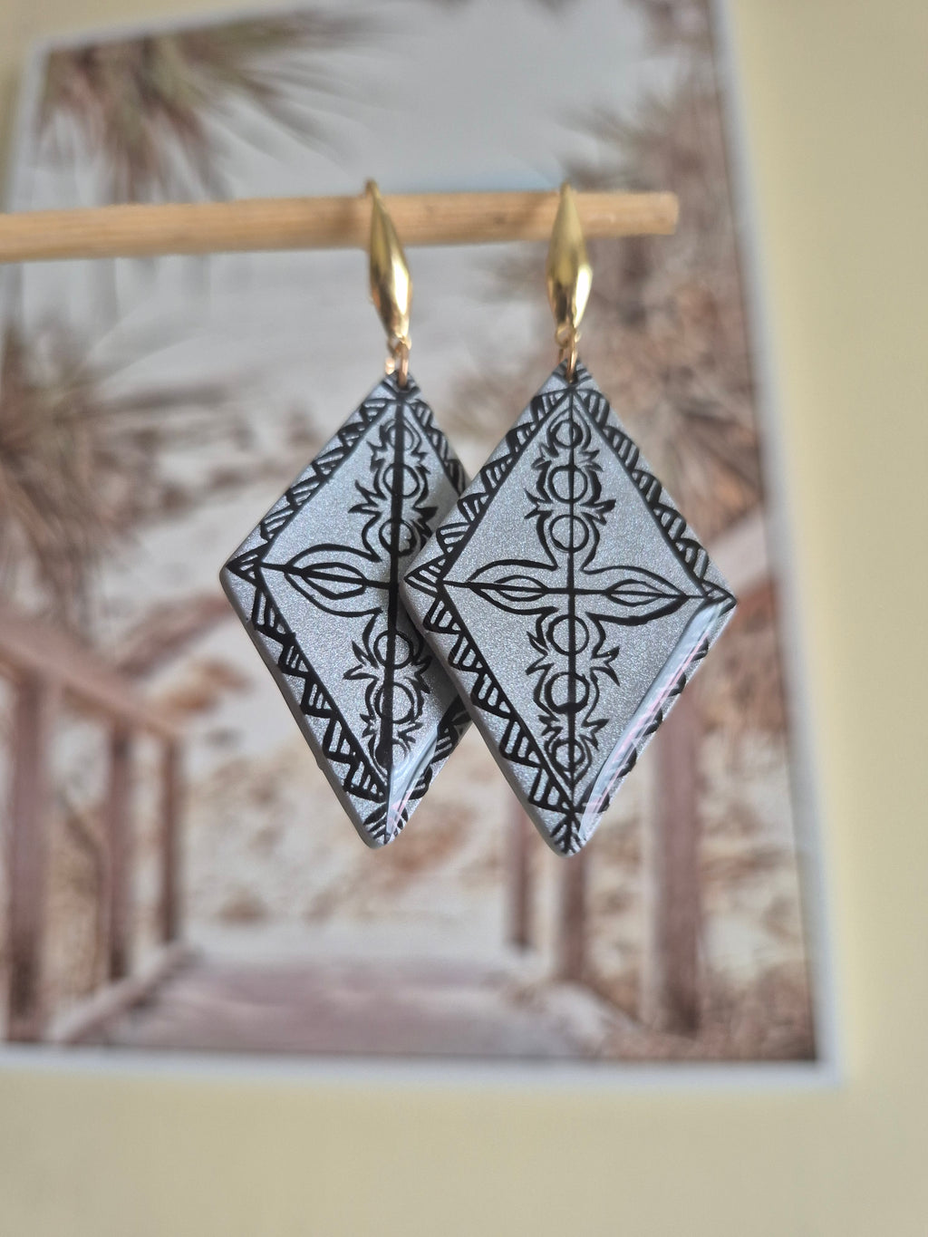 Gold hoop earrings with black-and-white geometric diamond dangles