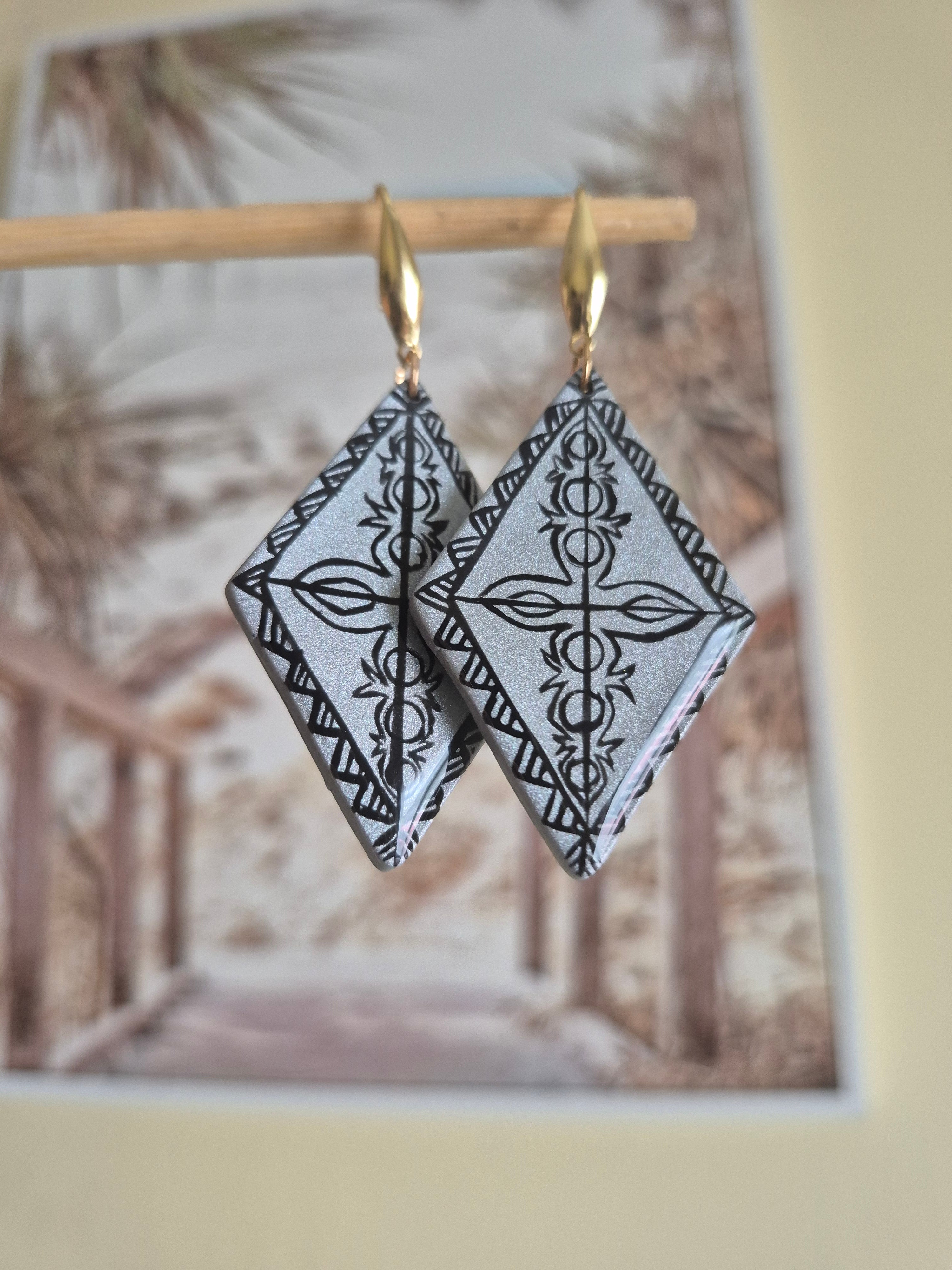 Gold hoop earrings with black-and-white geometric diamond dangles