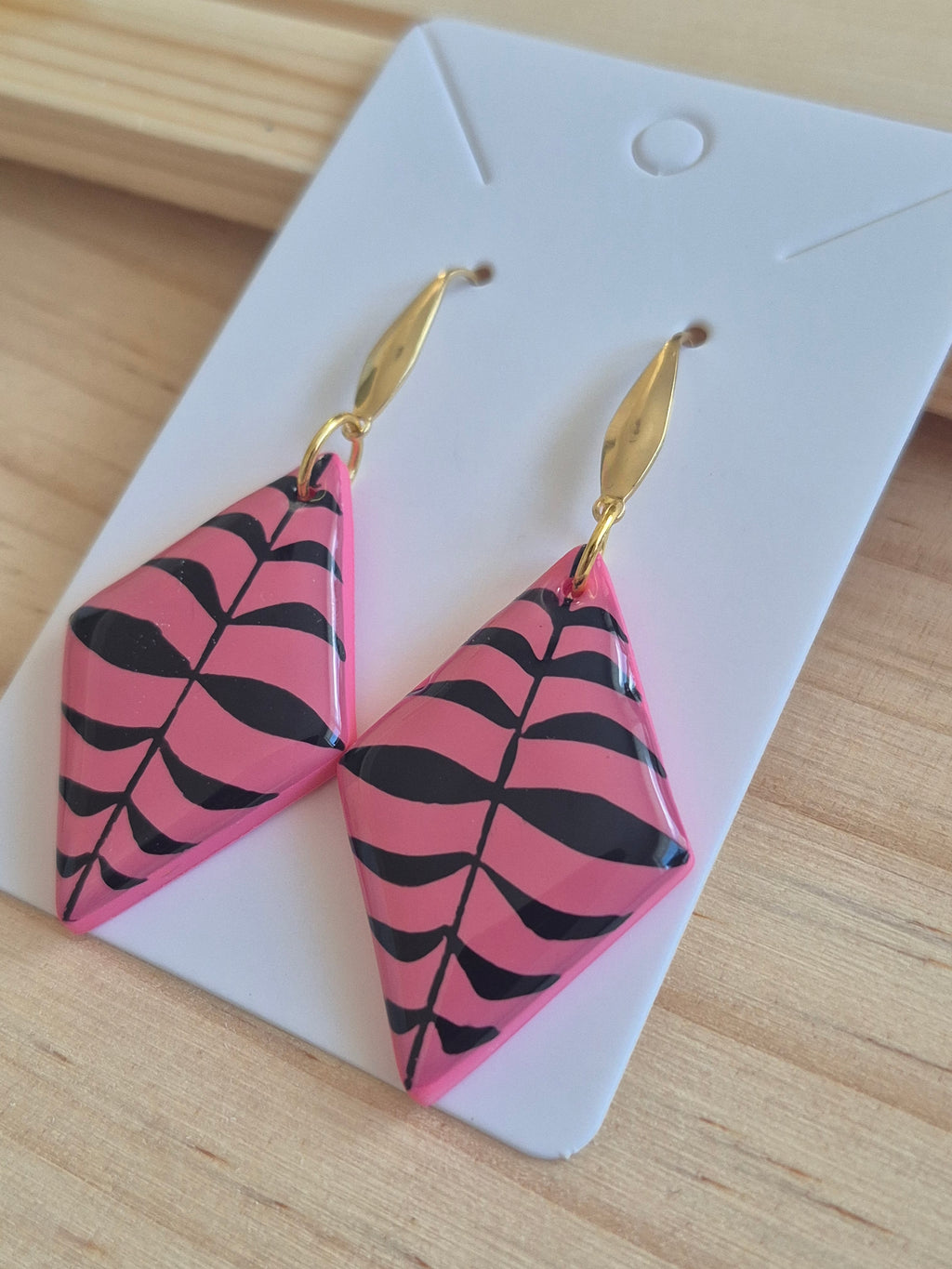 Pink and black patterned triangular drop earrings with gold-tone hooks