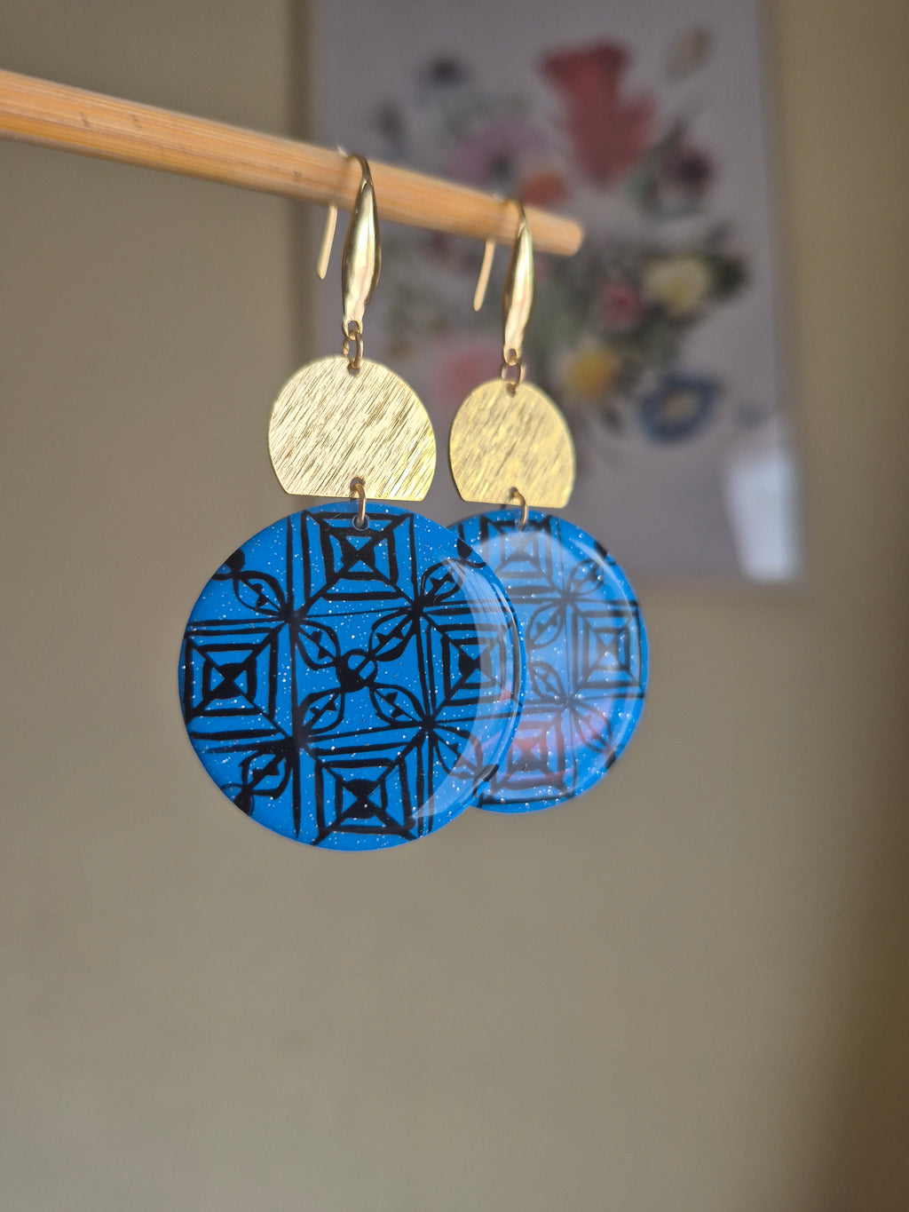 Layered blue geometric disc earrings with gold hooks and textured tan ear tops