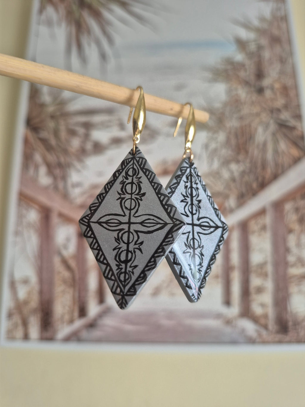 Gold-tone hoop earrings with black-and-white diamond drop design